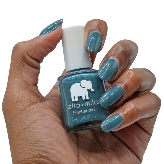 Twilight royal blue shimmer nail polish on a deep skin tone, hand holding the bottle
