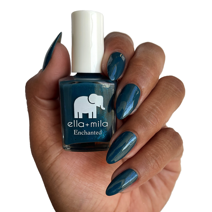 Twilight muted royal blue nail polish on a deep skin tone, holding the bottle