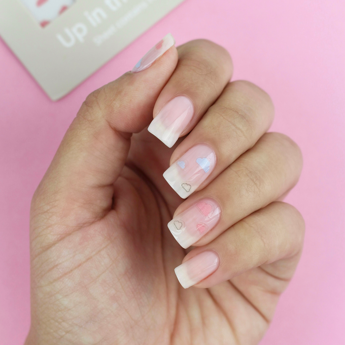 Up in the Clouds cloud decals on a sheer nude manicure with the packaging