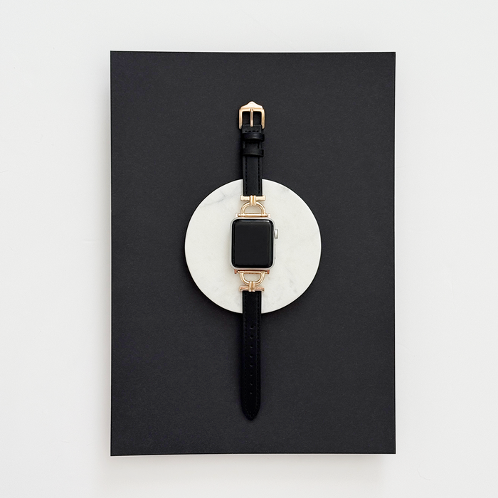 Kohl Black vegan PU leather Apple Watch strap displayed on a white stone with a black background.