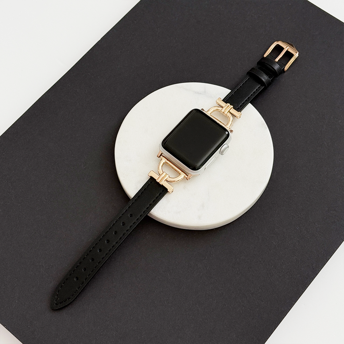 Black and gold smartwatch with a Kohl Black vegan leather strap on a white marble coaster.