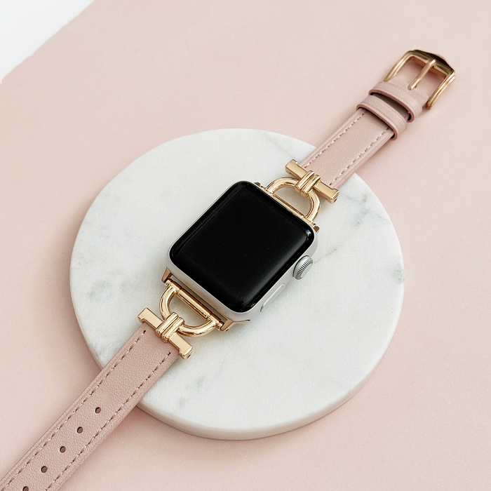 Pink Chai vegan PU leather Apple Watch strap with gold accents on white marble and pink background.