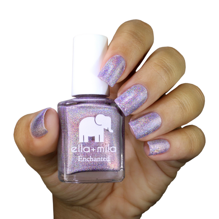 Zephyr holographic silver lilac nail polish on a medium skin tone, hand holding the bottle