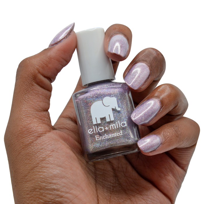 Zephyr holographic lilac nail polish on a deep skin tone, holding the bottle